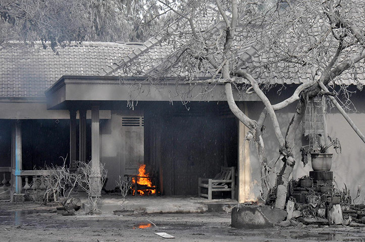 24 Hours: A fire burns amid ash-covered buildings in Central Java village Argomulyo