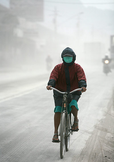 24 Hours: A residents passes a street covered by Mount Merapi ashes in Magelang