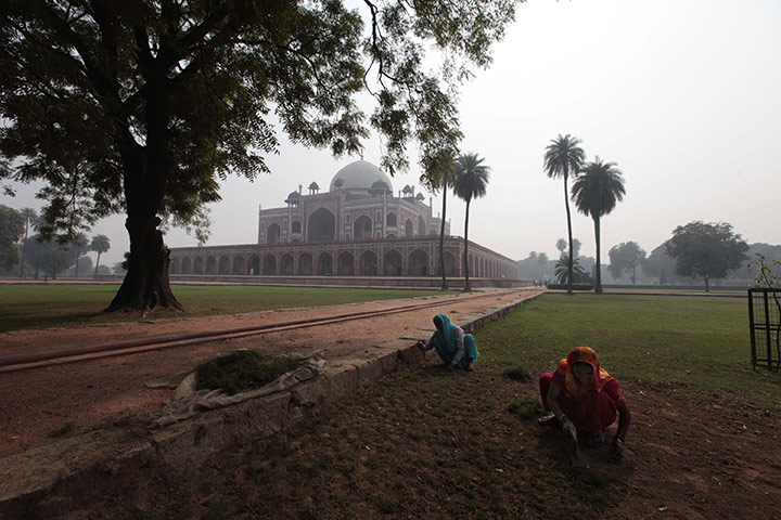 Obama Visit to Asia: Workers plant grass in the gardens surrounding Humayun's tomb in New Delhi