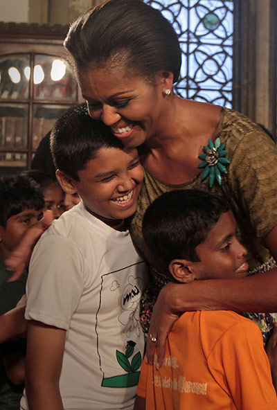 Obama in India: Michelle Obama hugs underprivileged children at the Mumbai University
