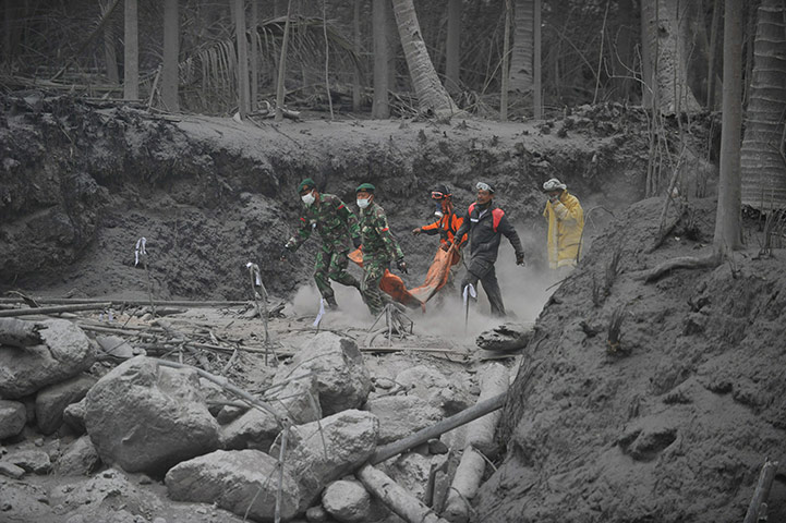 Mount Merapi: Rescue teams walk on the dry hot mud to evacuate victims of Mount Merapi