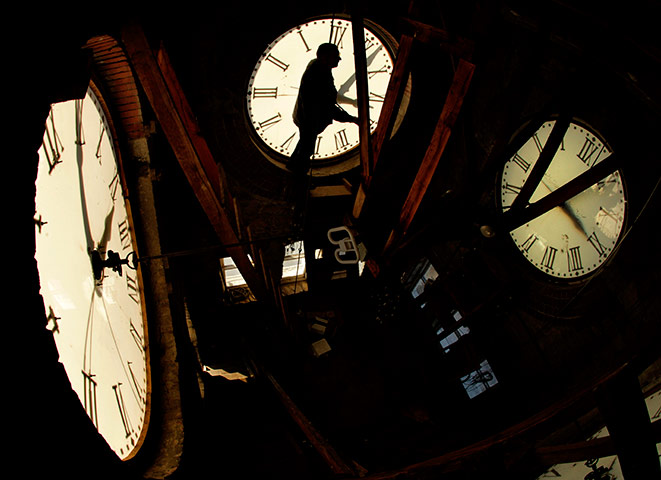 24 hours pics: Custodian Ray Keen checks the time on a clock face