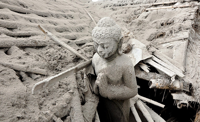 Mount Merapi: A Buddhist statue is covered with mountain ash 