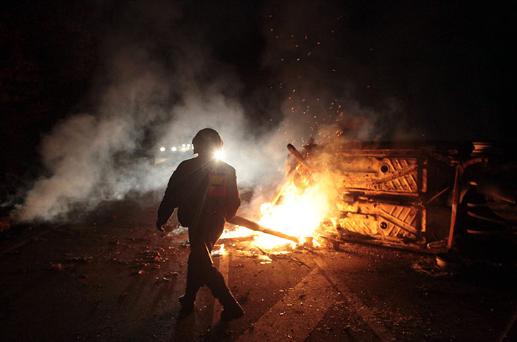 Anti-nuclear protests: Police clear a roadblock put up by activists using a car and bales of straw