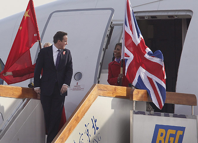 Cameron in China: David Cameron looks back while walking past flight attendants 