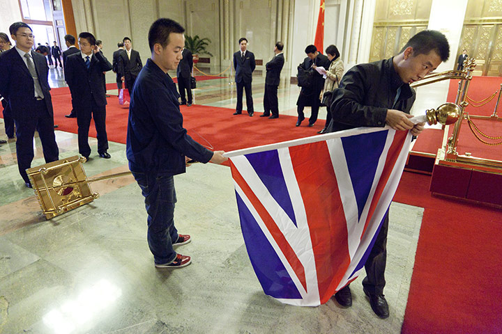 Cameron in China: Hall attendants fix the Chinese flag