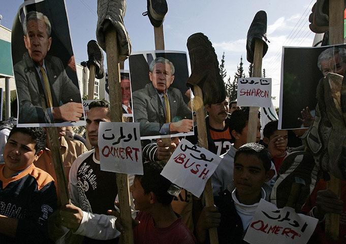 George W Bush: 19 December 2008: Palestinian demonstrators hold placards topped with shoes