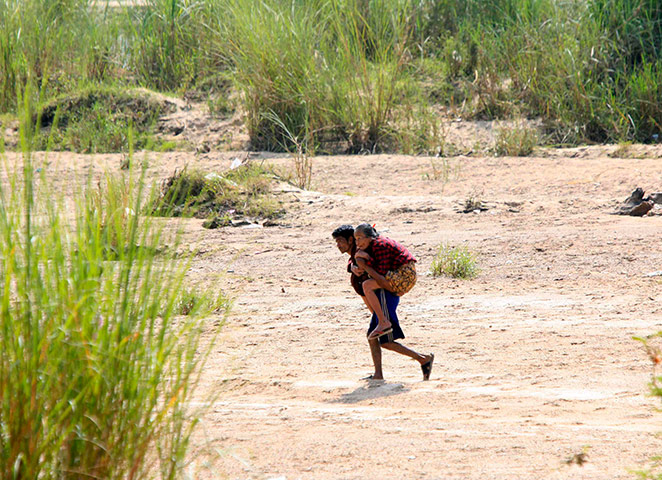 Burma refugees: Burma refugee carries his relative at the Thai border