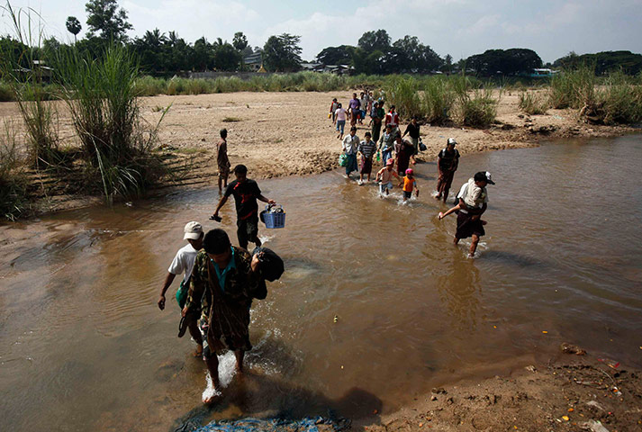 Burma refugees: Burma refugees cross a stream of water at the Thai border town of Mae Sot