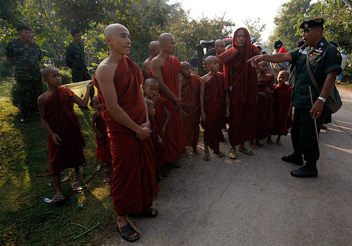 Burma refugees: A Thai policeman talks with a group of refugee Buddhist monks