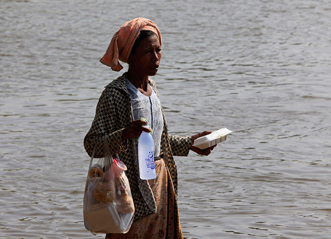 Burma refugees: A Burmese refugee holds food and water walks along Moei river