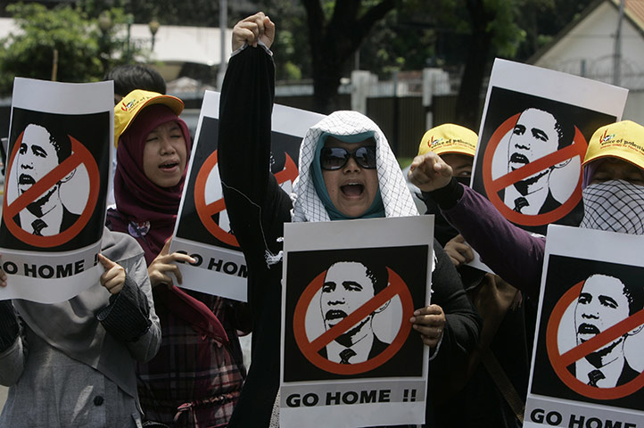 Obama indonesia: Women hold posters during a protest against the planned visit of Obama