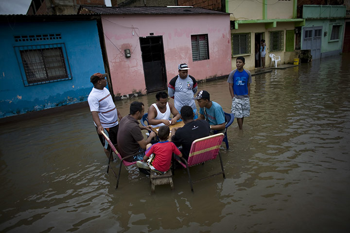Venezuela floods: People play dominos in a flooded street in Higuerote, Venezuela