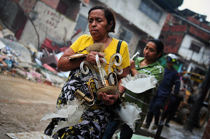 Venezuela floods: A woman carries some belongings rescued from the rubble of her house