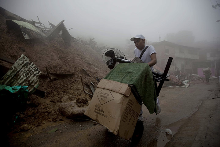 Venezuela floods: A man pushes his belongings as he evacuates from his home in Caracas