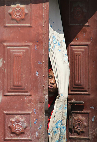 24 hours in pictures: A Yemeni woman peers out from behind a door 