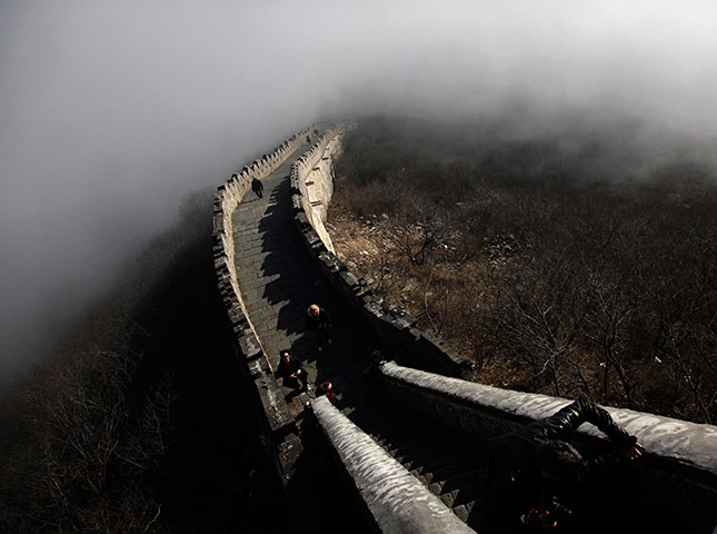 24 hours in pictures: Tourists walk along a section of the Great Wall shrouded in mist at Simatai