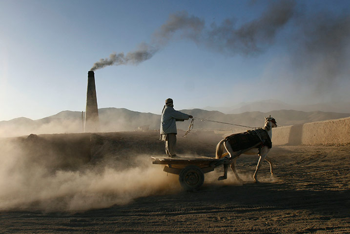 24 hours in pictures: An Afghan man rides on his horse drawn cart to collect bricks