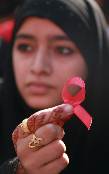 AIDS World day: A college student displays a red ribbon, the symbol for AIDS awareness