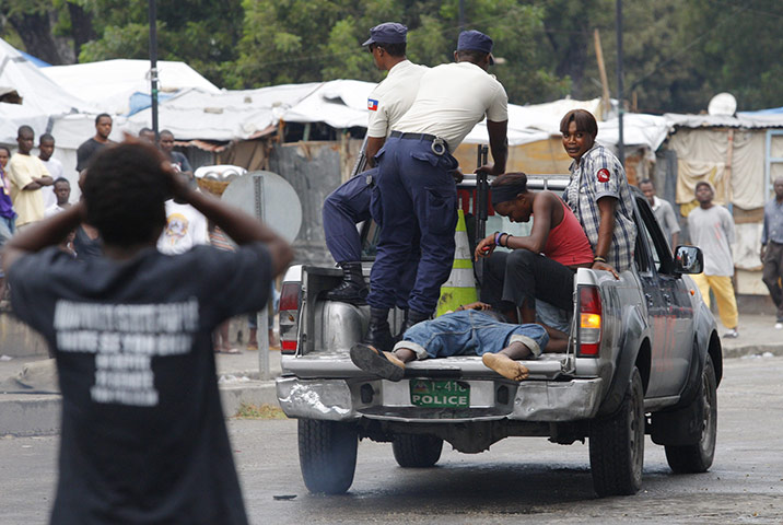 Violence in Haiti: An injured man is transported in a national police car