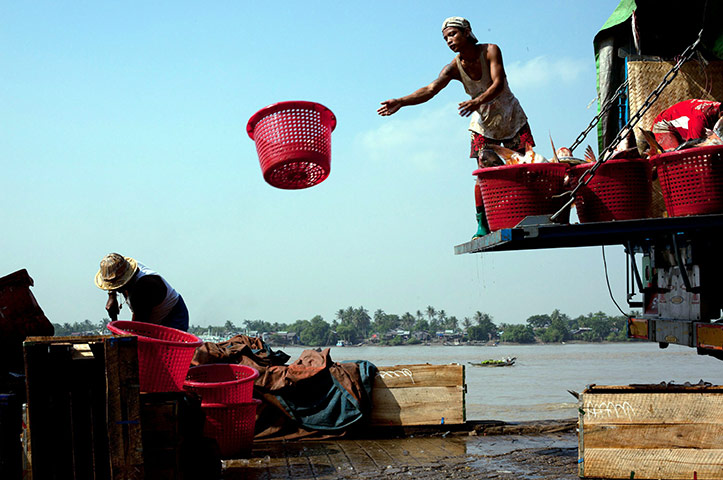 24 hours in pictures: Rangoon, Burma: Burmese men work on the docks of the San Pya fish market 