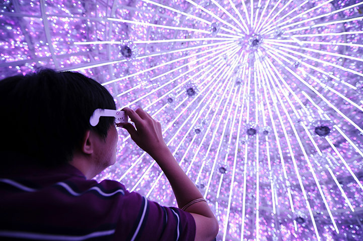 24 Hours in Pictures: A man looks up inside a six-storey high Christmas tree