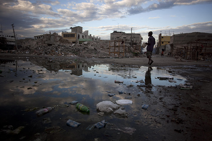 24 Hours in Pictures: A man downtown after riots over the conduct of the presidential election