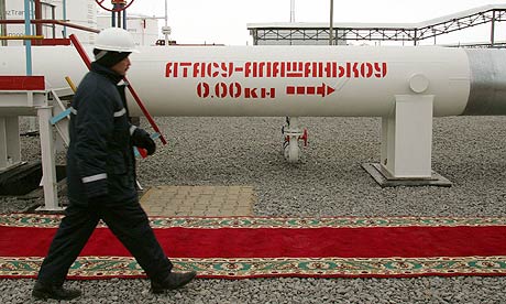 A Kazakh oil worker walks along an oil pipeline in Atasu