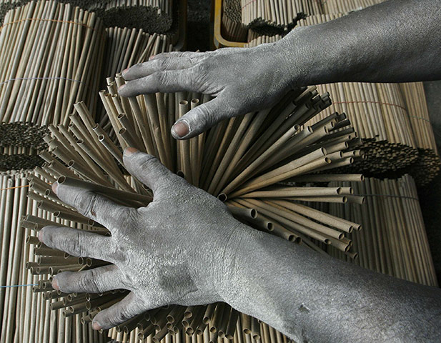 24 hours: Bulacan, Philippines: A worker's hands are covered in gunpowder