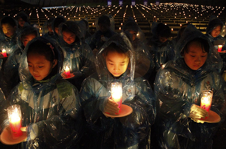 24 hours: Nanjing, China: Children hold red candles during a memorial ceremony