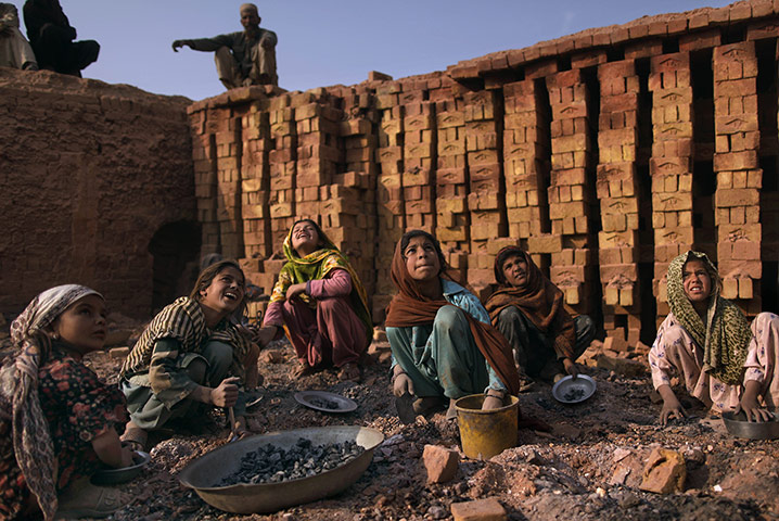 24 hours: Islamabad, Pakistan: Pakistani girls watch a man working at a brick factory