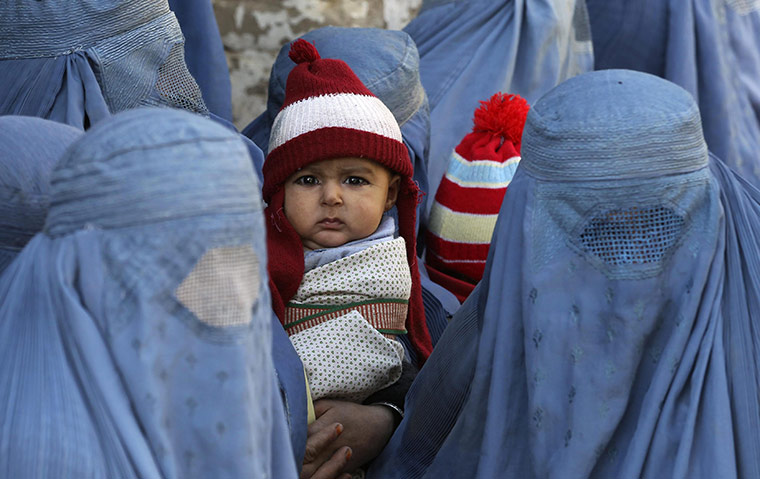 24 hours: Kunduz, Afghanistan: A baby boy and women wait for the distribution of food