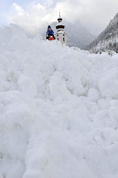 24 hours: Lofer, Austria: Marvin, 3, sits with his sledge in the snow