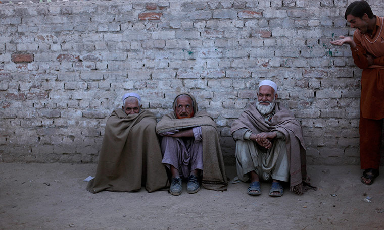 24 hours in pictures: An Afghan man gestures to elderly Afghan men