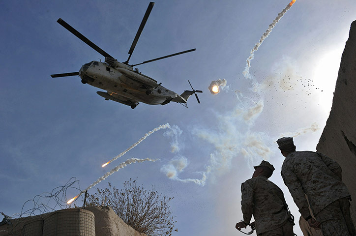 24 hours in pictures: US Marines watch a helicopter drop flares in Afghanistan