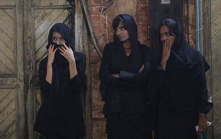 Ashura Religious Festival: Shi'ite Muslim women look at Shi'ite men walking on fire during Ashura