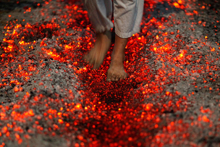 24 hours in pictures: A Shi'ite Muslim walks on fire at a ceremony during the Ashura festival