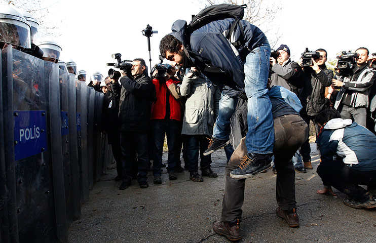 24 hours in pictures: Students act out playing leapfrog in front of a barricade of riot police