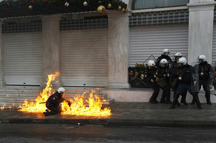 24 hours in pictures: A riot police member is attacked with petrol bombs during protest in Athens