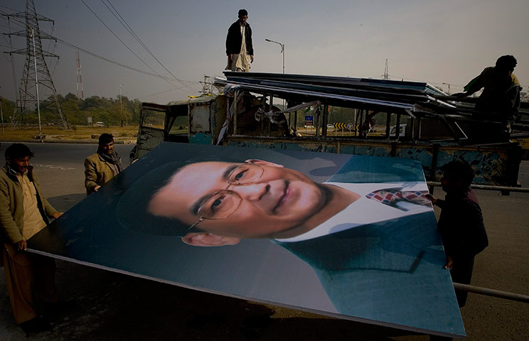 24 hours in pictures: Pakistan workers unload a huge portrait of Chinese Premier Wen Jiabao