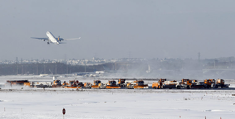 Winter Weather Europe: Snowploughs clear runways as a plane takes off after snowfall at Frankfurt