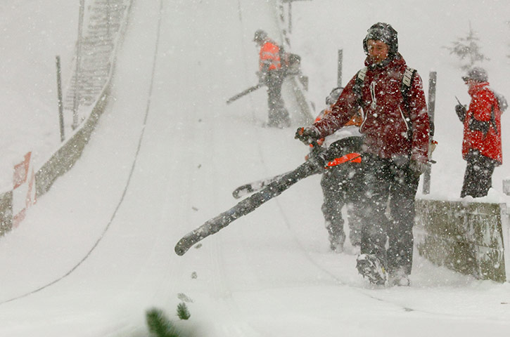 Winter Weather Europe: Workers use blowers to remove extra snow during ski jumping in Engelberg