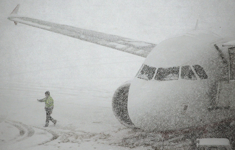 Winter Weather Europe: A worker walks past a plane parked at Zurich airport in Kloten