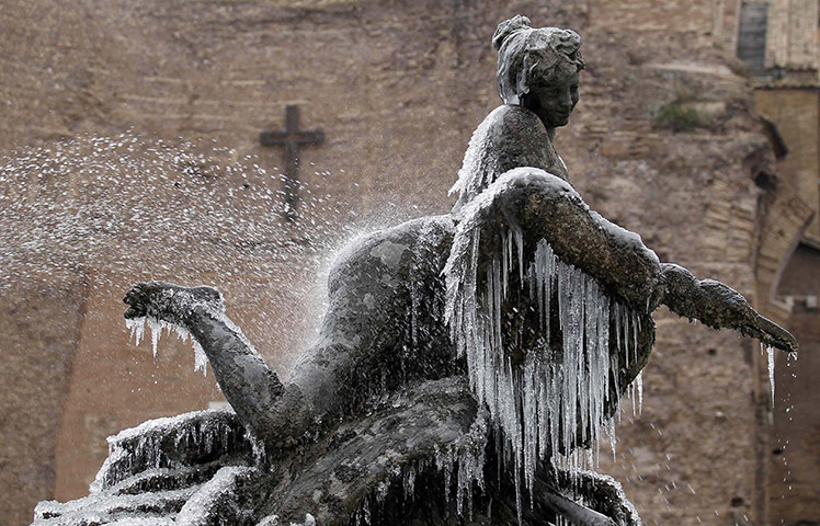 Winter Weather Europe: A spray of water from the Fountain of the Naiads statue with icicles Rome