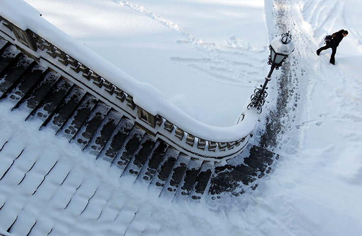 24 hours in pictures: A woman strolls next to snow covered stairs in Munich