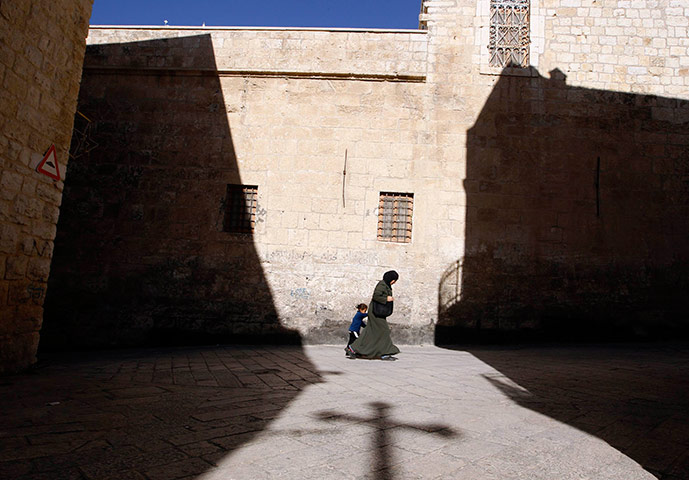 24 hours in pictures: Palestinian woman walks past the Church of the Nativity in Bethlehem