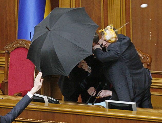 Parliamentary Brawls: Guards cover parliament speaker Volodymr Lytvyn with an umbrella from eggs