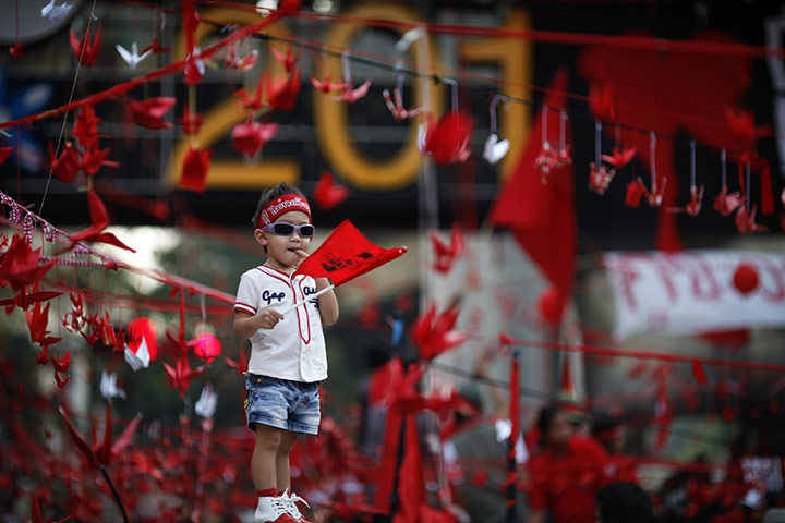 24 hours: Bangkok, Thailand: A boy joins Thai anti-government red shirt protesters