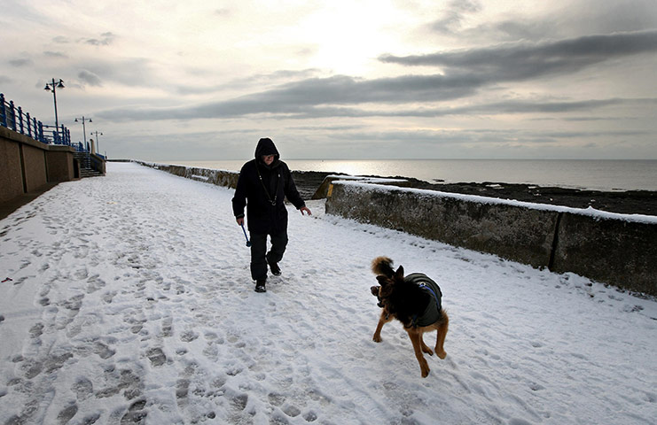 Cold weather continues: Collin Woods and his dog Zeb take a snowy walk on Porthcawl seafront