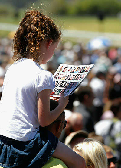 Girl looking at photos of miners at New Zealand memorial service